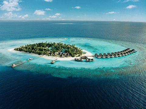 Aerial of Nova Maldives, small natural island with greenery and expansive lagoon