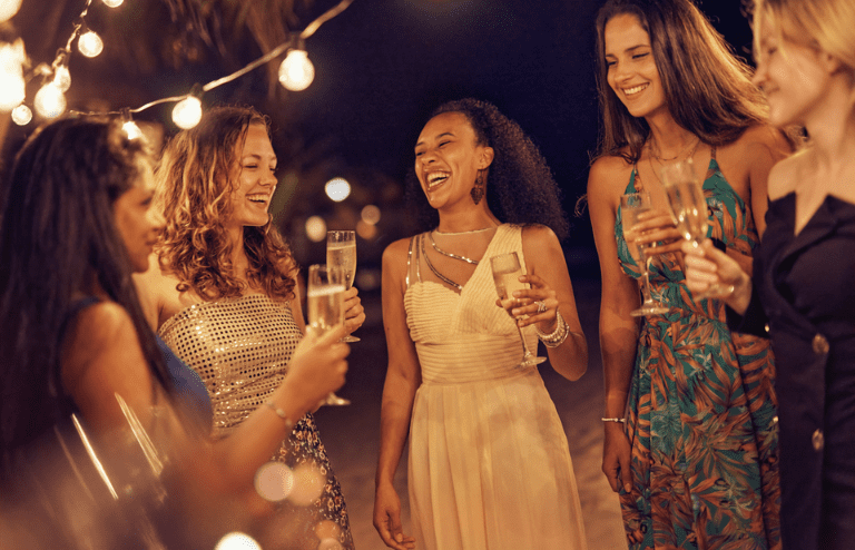 a group of women holding drinks having fun