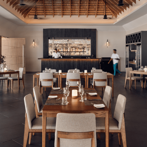 a restaurant with tables and chairs and two servers