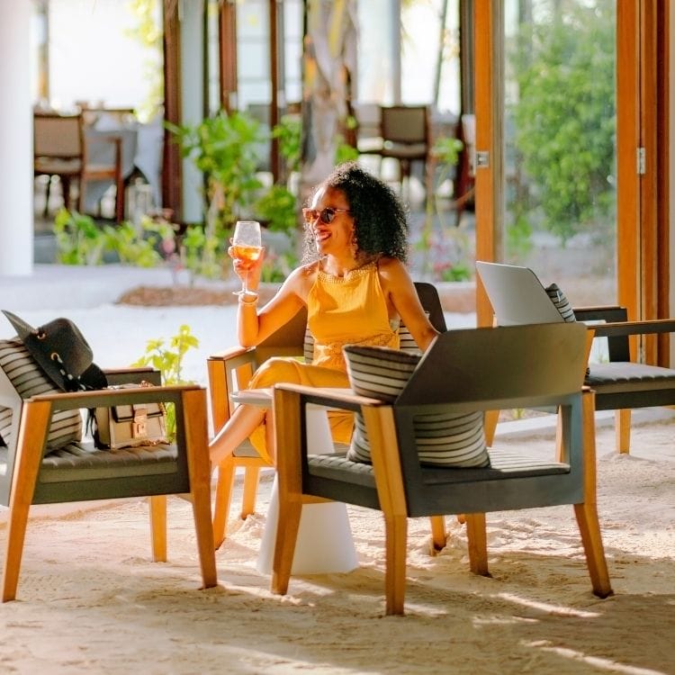 A woman sitting with a wine glass at Wink