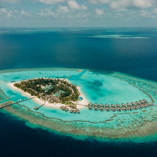 Aerial of Nova Maldives, small natural island with greenery and expansive lagoon