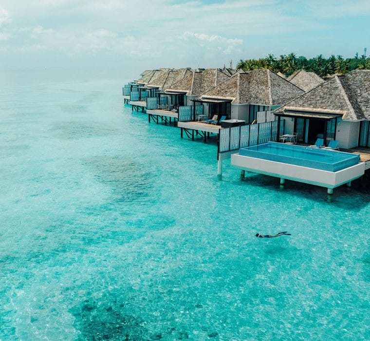 Exterior of water pool villa with a snorkeller in the water